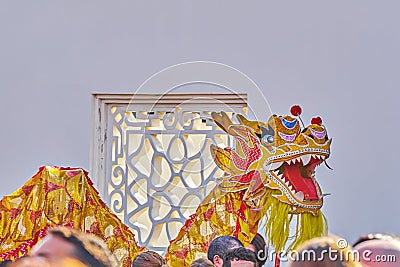 Traditional Chinese golden Dragon dancing around crowd in Chinese Garden during celebration of Chinese New Year Editorial Stock Photo