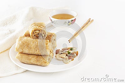 Traditional Chinese tortillas filled - bings in a plate with mushrooms on a white background, cup of tea. Stock Photo