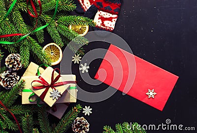 Traditional Christmas dark background top view. New Year composition Spruce branch Pine cone Presents Orange Snowflakes Stock Photo