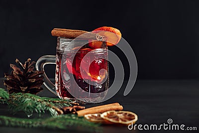 Traditional Christmas warming mulled wine. Hot drink with spices in glass cup on dark background Stock Photo