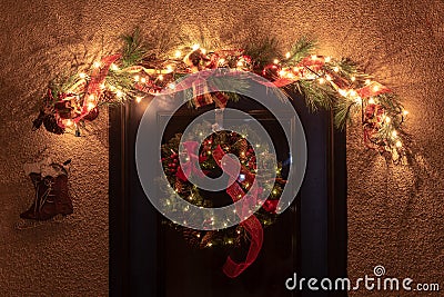 Traditional Christmas wreath hung on door with other holiday decorations Stock Photo