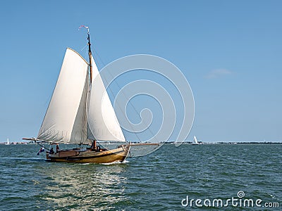 Traditional classic sailboat sailing under full sails on IJsselmeer lake, Netherlands Editorial Stock Photo