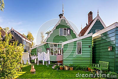 Traditional courtyard of Dutch old house. Laundered clothes are dried in the yard. Cat sits under a bench. Stock Photo