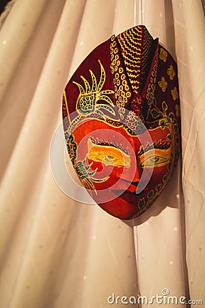 Red Indonesian Wayang Mask on a white curtain Stock Photo