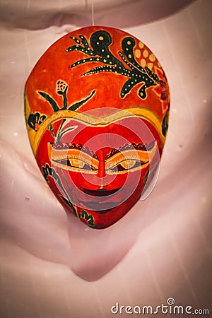 Red Indonesian Wayang Mask on a white curtain Stock Photo