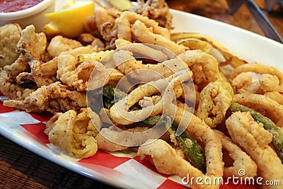 Traditional delicious fried calamari rings with fried vegetables Stock Photo