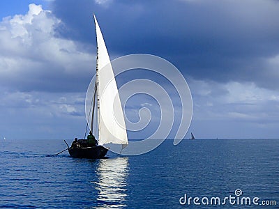 Traditional dhow sailing on a calm sea Stock Photo