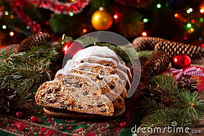 Traditional Dresdner German Christmas cake Stollen with raising, berries and nuts. Celebration decorations. Stock Photo