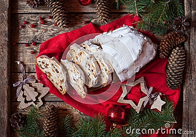 Traditional Dresdner German Christmas cake Stollen with raising, berries and nuts. Holiday xmas decorations. Stock Photo