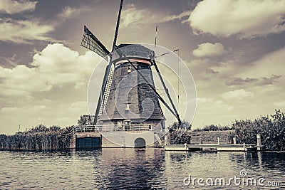 Traditional Dutch windmill in old-fashioned effect with dramatic cloudy sky Stock Photo