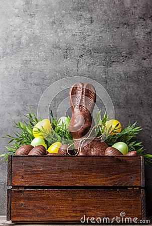 Traditional Easter chocolate bunny and eggs inside a wooden crate Stock Photo