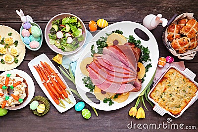 Traditional Easter ham dinner. Top down view table scene on a dark wood background. Stock Photo