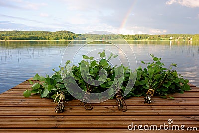 Traditional Finnish bath whisks on a jetty by the lake Stock Photo