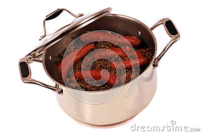 Smoked sausages and lentils in a stainless steel Dutch oven close-up on white background Stock Photo