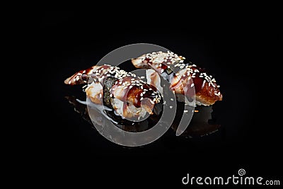 Traditional fresh Delicious Unagi Eel Nigiri Sushi Eel Sushi on a black background with reflection. Traditional Japanese Stock Photo