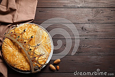 Traditional galette des rois with decorative crown on wooden table, flat lay. Space for text Stock Photo