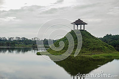 Traditional Gazebo Temple on Top of Green Hill in the middle of the lake Stock Photo