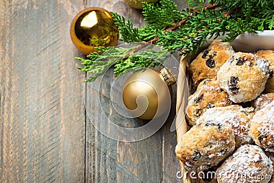 Traditional German Austrian Swiss Christmas pastry mini stollen cakes or cookies in wicker basket and on wood table golden balls Stock Photo