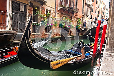 Traditional gondola in venetian water canal in Venice, Italy. Black gondola in Venezia Stock Photo