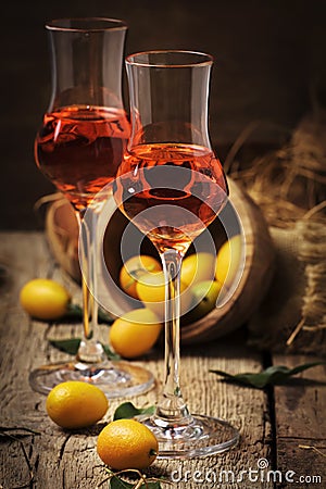 Traditional greek kumquat liqueur in shot glass, vintagen background, rustic style, selective focus Stock Photo