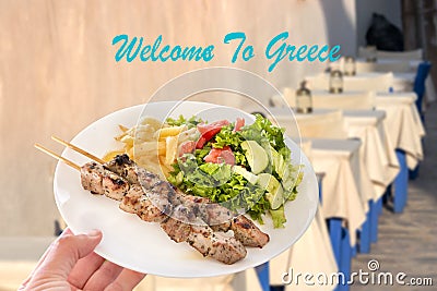 A traditional greek pork souvlaki plate over a tavern background. Welcome to Greece concept Stock Photo