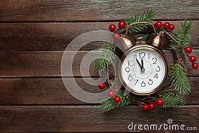 Traditional handmade Christmas wreath with green fir tree branches holly berries clock showing five minutes to midnight countdown Stock Photo