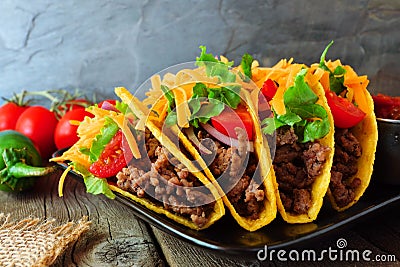 Hard shelled tacos with ground beef, vegetables and cheese, close up scene Stock Photo