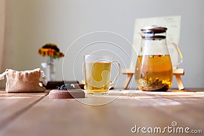 Traditional heral tea with glass teapot, cup, dried rose buds. Flowers on wooden table at home,sunlight background Stock Photo