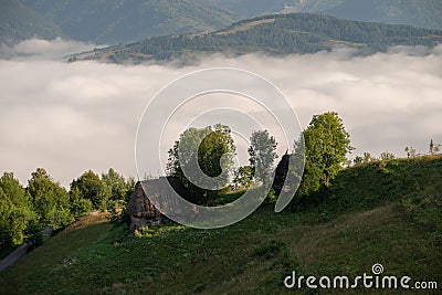 Traditional homes in Transylvania , sunrise with mist in the mountains , Romania Editorial Stock Photo