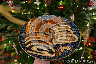 traditional hungarian christmas cookie calles bejgli filled with walnut and poppy seed with christmas tree background Stock Photo