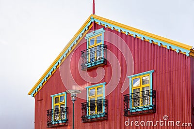 Traditional Icelandic red ironclad building with colorful windows and roof, Reykjavik, Stock Photo