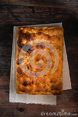 Traditional Italian Focaccia. Homemade flat bread focaccia on wooden table. Stock Photo