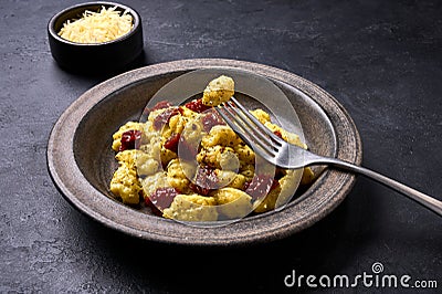 Traditional Italian potato gnocchi pricked on a fork lying on plate with dish Stock Photo