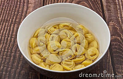 Traditional Italian Tortellini in brodo on wooden table Stock Photo