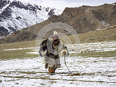 Traditional Kazakh eagle hunter with his golden eagle against th Editorial Stock Photo