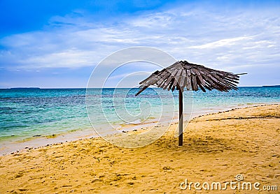 Traditional lazy hut yellow sandy beach in the clear blue morning sky Stock Photo