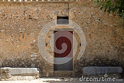 Traditional Mallorcan house with thick wooden door. Typical stone house of the Mediterranean. Holiday home to spend the summer in Stock Photo