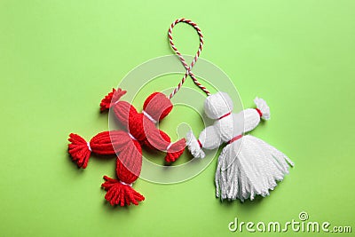 Traditional martisor shaped as man and woman on green background, top view. Beginning of spring celebration Stock Photo