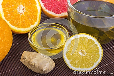 Traditional medicine, health, ethnoscience concept and folk remedy - cup of herbal tea, honey, ginger, orange and grapefruit Stock Photo