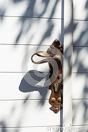 Traditional mediterranean background consisting of arhitectural detail of white wooden door with brass doorknob with Editorial Stock Photo