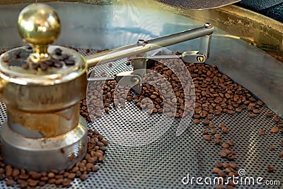 Traditional method of roasting dried organic arabica coffee beans in roster with open grid for cooling, bio coffee farm Stock Photo