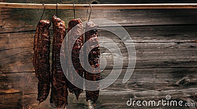 Traditional method of smoking meat in smoke. Smoked ham, bacon, pork neck and sausages in a smokehouse Stock Photo