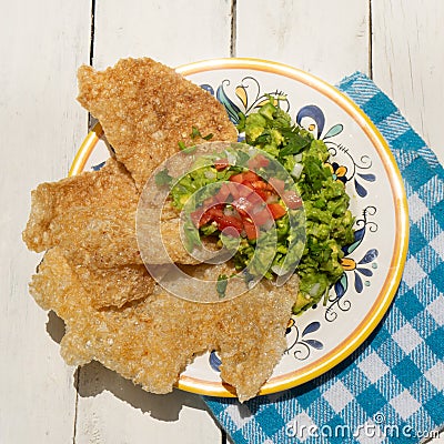 Mexican guacamole with pork chicharron on white background Stock Photo