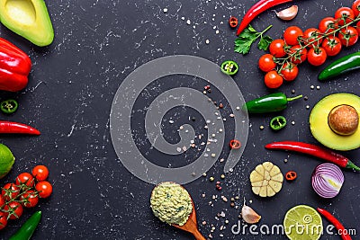 Traditional Mexican Guacamole sauce in spoon and ingredients on black stone table. Top view with copy space Stock Photo