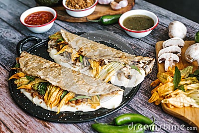 Traditional mexican quesadillas of chicharron or mushrooms, oaxaca cheese, squash blossom and epazote in corn tortillas in Mexico Stock Photo