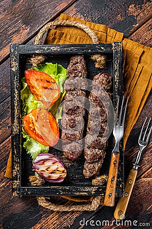 Traditional middle east kefta or kofta kebab, ground beef and lamb meat grilled on skewers served with tomato, salad and Stock Photo