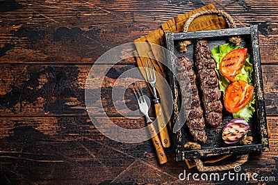 Traditional middle east kefta or kofta kebab, ground beef and lamb meat grilled on skewers served with tomato, salad and Stock Photo