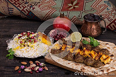 Traditional Middle eastern Persian chicken and lamb meat Shashlik Kebab skewered meat BBQ Grill on flat pita bread and saffron r Stock Photo