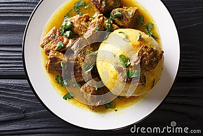 Traditional Mofongo with plantains, garlic and chicharron served with meat and broth close-up on a plate. horizontal top view Stock Photo