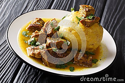 Traditional Mofongo with plantains, garlic and chicharron served with meat and broth close-up on a plate. horizontal Stock Photo